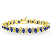 Yellow Gold Flashed Sterling Silver Created Blue Sapphire 6x4mm Oval and S Tennis Bracelet with White Topaz Accents