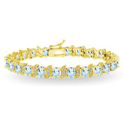 Yellow Gold Flashed Sterling Silver Blue Topaz 6x4mm Oval and S Tennis Bracelet with White Topaz Accents
